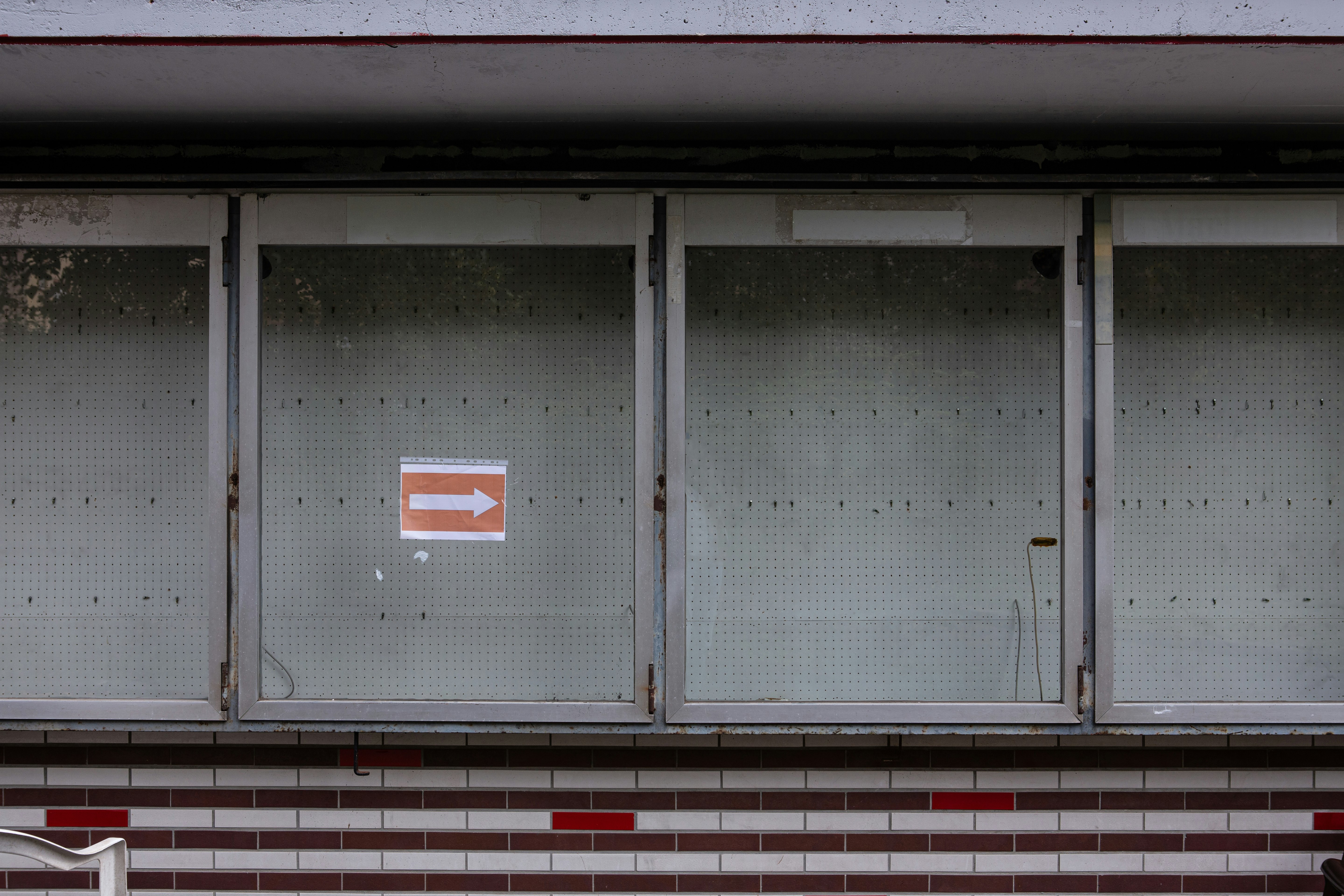 white and red arrow sign on gray steel door